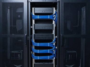 Straight-on geometric crop of structured server racks with clean blue cable management, cool high-contrast studio lighting, sharp architectural focus.