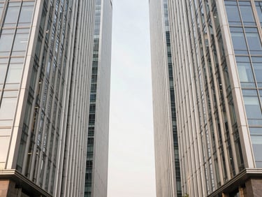 Symmetric architectural photograph of a modern luxury glass and steel skyscraper in Noida, bright natural daylight, clean minimalist lines, desaturated warm tones, 35mm lens