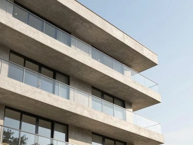 Modern luxury apartment exterior with clean concrete balconies and large glass windows under clear daylight