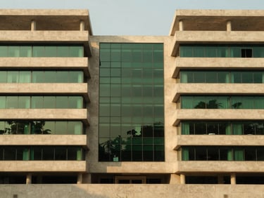 Symmetrical view of a modern architectural model in our Islamabad headquarters, clean lines, concrete and glass details, soft studio lighting, 35mm