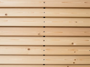 Clean, straight-on view of a newly graded timber retaining wall, displaying perfectly aligned horizontal beams and integrated drainage outlets.