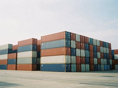 Wide-angle architectural film photography of a large, modern shipping port with containers stacked neatly, soft natural overcast light, desaturated cool tones, 35mm wide-angle.