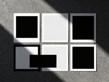 Overhead flat-lay of a creative direction mood board on a dark concrete table, sharp dramatic shadows, minimalist composition, 35mm film look