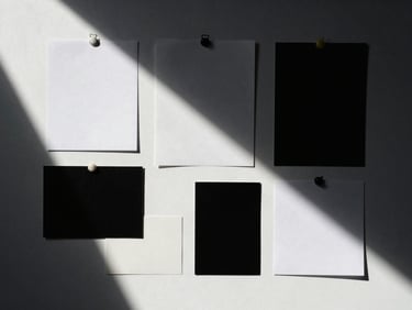 Overhead flat-lay of a creative direction mood board with deep dramatic shadows, high-contrast studio lighting, minimalist composition, 35mm film look.
