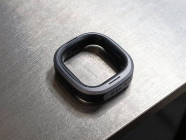 Top-down clean studio layout of an IP67 certified smart wearable safety device on a brushed steel plate, sharp shadows