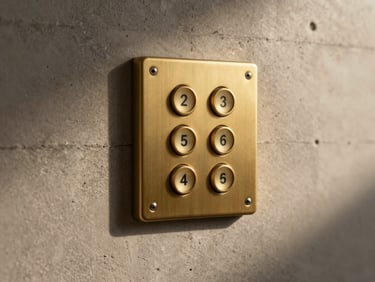 Extreme close-up of a flush-mounted single-gang brass keypad integrated seamlessly into a raw concrete wall, warm low-temperature architectural lighting casting soft shadows.