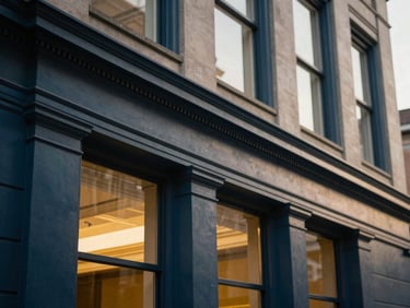 Architectural detail of a classic legal building facade, strong lines, soft morning light, deep navy and golden tones, 35mm