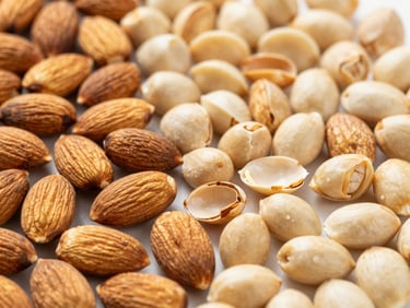 Arrangement of raw almonds, some shelled, some unshelled, on a clean surface, bright natural light