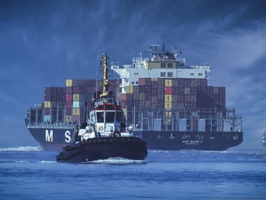 a tugboat with a large container ship in the background