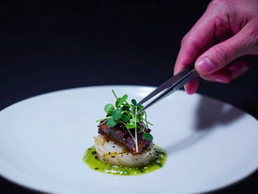 Close-up of an artisan dish being plated under dramatic spotlighting, micro-greens placed with tweezers, dark moody background, high contrast, 35mm