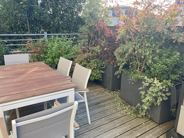 Terrasse aménagée avec nombreux bacs d'arbustes à fleurs
