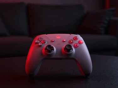 Moody low-key shot of a modern gaming controller glowing with soft red light in a dark lounge