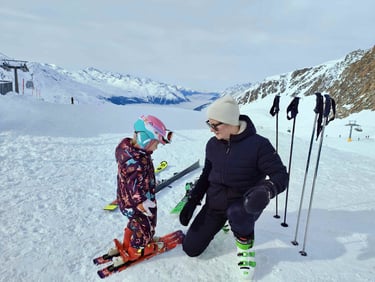 a woman and a child are standing in the snow