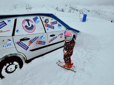 a kid standing in the snow with a snowboard