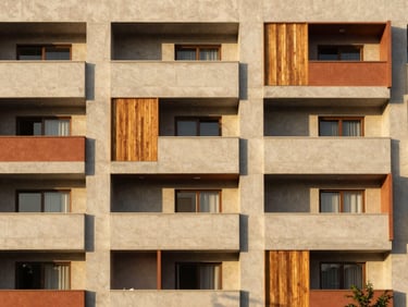 Facade of a modern multi-family residential building in Tacna, clean lines, terracotta accents, golden-hour sunlight, architectural photography, 35mm lens.