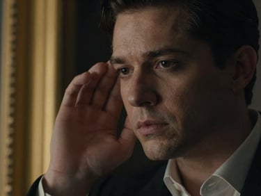 High-contrast video frame from Talking to Me, close-up of Sedater Saviour listening intently, dramatic side-lighting, elegant gold accents in background, 16:9 aspect ratio.