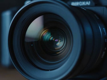 Extreme close-up of a high-definition camera lens reflecting cool blue studio lights, cinematic dark-mode, 35mm film