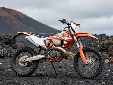 Close-up of a KTM EXC 250 dirt bike parked on volcanic rock terrain in Bali, overcast light revealing orange frame and knobby tires caked with dried mud, wide environmental framing showing rocky slope behind