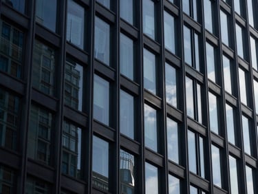 Abstract architectural details of a modern building facade, glass and steel, dramatic shadows, cool corporate daylight, deep navy tones, reflecting official documents.