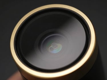 Macro close-up of MIREV aesthetic device, gold rim lighting, black mirror glass finish, 85mm