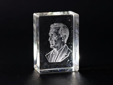 dramatic low-key product photography, sharp backlighting, dark obsidian background, glowing glass refraction, macro lens, 50mm, a heavy optical-grade crystal block with a 3D laser-etched portrait suspended inside, catching light from the side