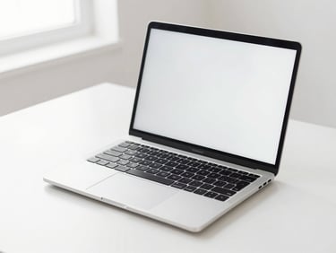 Sleek silver laptop open on a clean white desk, bright natural light, sharp focus on keyboard and screen, minimalist background