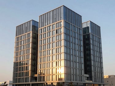 Wide architectural shot of a modern commercial building with structural glass curtain wall reflecting golden hour sunlight, Riyadh