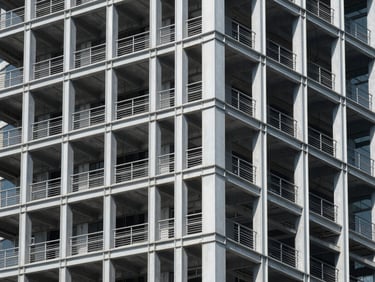 Exposed steel framework of a modern high-rise under bright daylight, clean geometric shadows, architectural photography