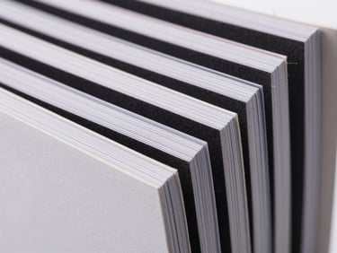 Macro shot of a multi-page product catalog spine, showing perfect binding and crisp page edges, sharp studio lighting, high-contrast.