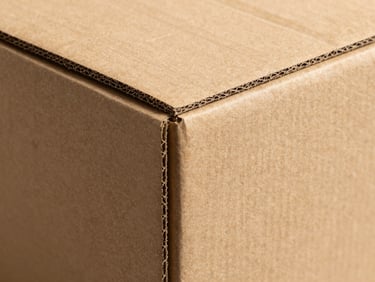 Close-up of a perfectly folded corrugated box, showing clean edges and structural integrity, industrial workshop light, high contrast.