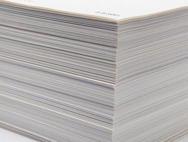 Close-up of a stack of neatly bound bill books with crisp numbering, sharp studio lighting, high-contrast textures.