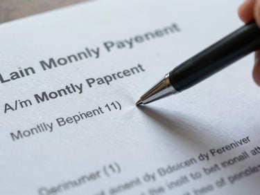 Tight overhead shot of a loan document with a pen pointing at a monthly payment figure, cool daylight, sharp focus on the number