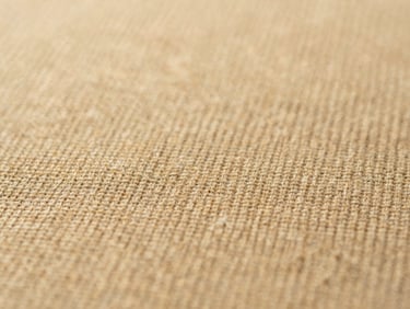 Macro photograph of organic mercerized cotton fabric weave, warm sand tones, shallow depth of field