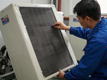 Technician examining the condenser coils and compressor unit of a Challenger commercial cooler, unit tilted forward, Challenger serial plate clearly visible, natural indoor light