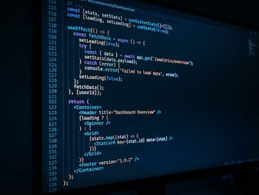 A close-up of clean React code on a high-end monitor in a dark studio, illuminated by a sharp electric blue ambient glow, shallow depth of field.