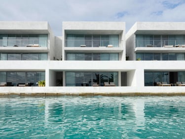 Bright modern waterfront residence in Cancun, clean architectural lines, turquoise water reflection on white concrete