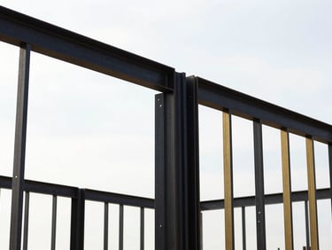 Close-up of clean structural steel framing on a residential construction site, bright overcast sky, high-contrast