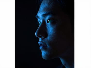 Focused human profile in deep concentration, subtle glowing deep blue luminescence highlighting facial contours, dark obsidian background, extreme macro shot, moody editorial photography, 35mm