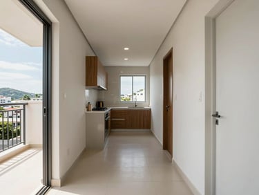 Entry hallway of a three-bedroom apartment in Balneário Camboriú, wide-angle view showing kitchen opening, natural daylight from balcony door, no furniture, clean finishes