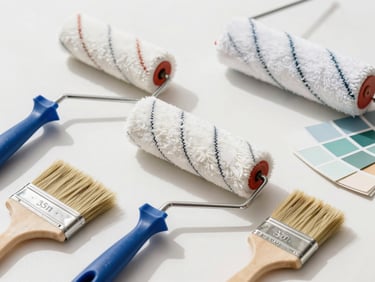 Bright editorial photography of clean professional paint rollers and high-quality bristle brushes arranged neatly on a work surface, bright daylight, 35mm