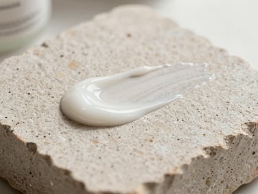 Macro shot of premium skincare textures on neutral stone, bright clinical daylight.