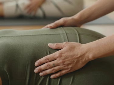 Close-up of hands gently guiding a yoga pose in a private session, soft diffused light, focus on connection and support, warm earthy tones.