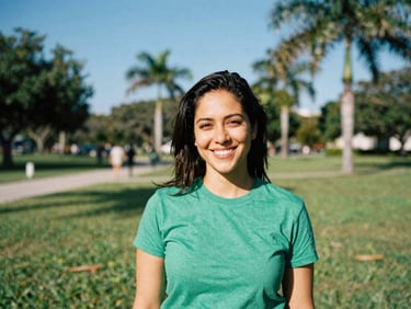 Candid portrait of a woman in a green t-shirt smiling in a sun-drenched Florida park, 35mm.