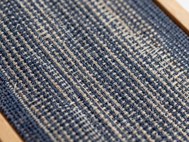 Macro shot of woven linen fabric texture, deep navy and natural beige threads, crisp daylight, professional industrial photography, 35mm