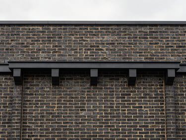 Straight-on architectural view of clean, master-grade brickwork and structural lintels on a completed renovation in Manchester.