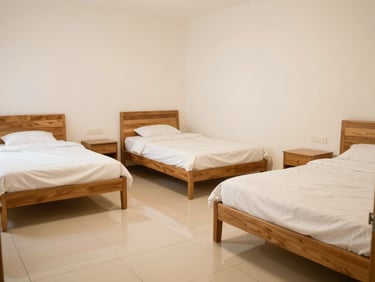 A spacious triple sharing room for women, neatly arranged beds, clean tiled floors, and soft warm lighting, 35mm photography