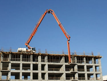 A long orange concrete boom pump extending high into the sky over a multi-story building construction site in Maceió, bright midday sun, high contrast, industrial site photography