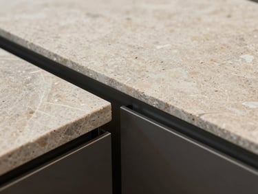 Close-up of high-end raw materials, natural stone meeting dark steel trim, precise alignment, sharp architectural lighting, minimalist texture.