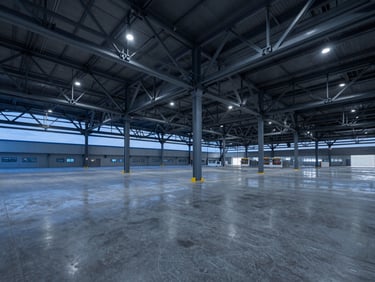 Wide-angle architectural shot of a massive industrial logistics center with exposed steel trusses and polished concrete floors, blue hour lighting
