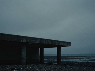 Moody cinematic film still, low-key dramatic lighting, an isolated concrete pier on the Irish coast under heavy overcast skies, desaturated cool tones, anamorphic lens, 35mm grain